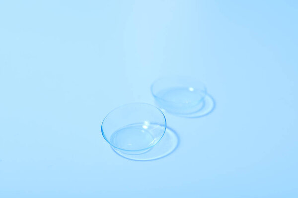 Transparent contact lenses for eyes on a blue background