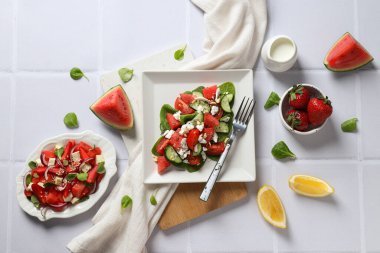 Beyaz arka planda limonlu ve çilekli karpuz salatası.