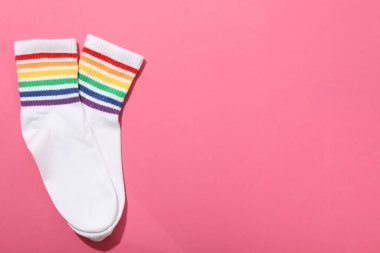 LGBT geçit töreni konsepti, pembe arkaplanda renkli semboller.
