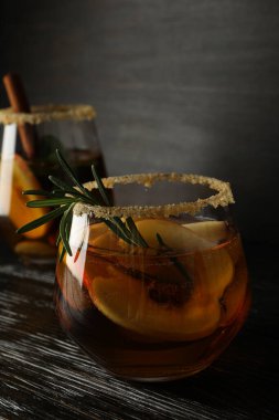 Koyu ahşap arka planda elma suyu bardakları, kapatın.