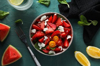 Kasede karpuz salatası ve arka planda bir bardak su.