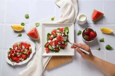 Beyaz arka planda limonlu ve çilekli karpuz salatası.