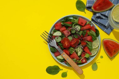 Kasede taze karpuz salatası ve sarı arka planda bir bardak limonata.