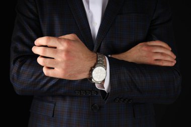 Siyah arka planda siyah takım elbiseli bir adam.