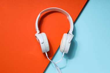 Beyaz, tam boy, mavi-turuncu arka planda kablolu kulaklık..