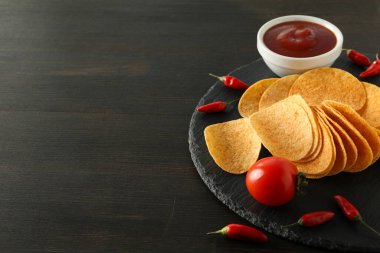 Biber ve sosla dolu bir kasede patates cipsi