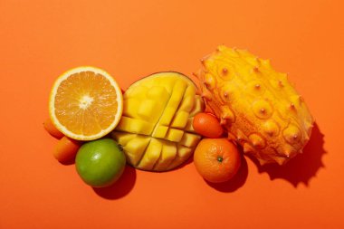 Turuncu arka planda tropik meyve seti, üst görünüm