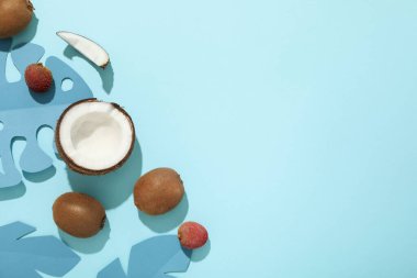 Mavi zemin üzerinde tropikal meyve ve kağıt yaprakları kümesi, metin için boşluk