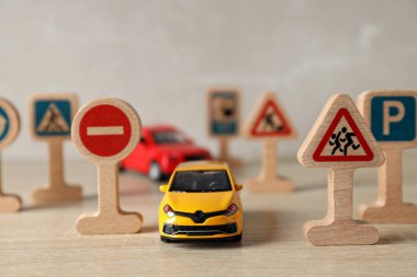 Hafif arka planda trafik işaretleri ve araçlar.