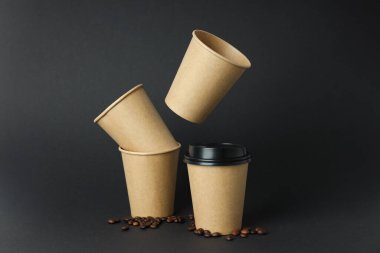 Kahve fincanları, kahve çekirdekleri ve siyah bir arka plan.