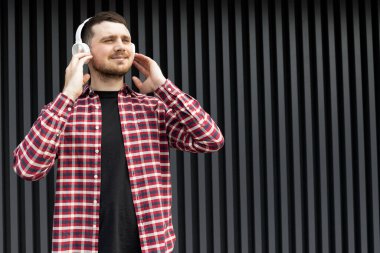 Çekici genç adam kulaklıkla müzik dinliyor.