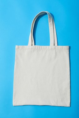 Mavi arka planda beyaz bir çanta var.