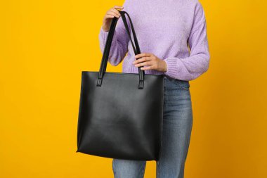 Sarı arka planda siyah çanta.