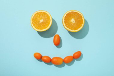 Tüm kumkatlar ve portakalın iki yarısı mavi arka planda.