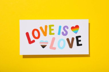 LGBT geçit töreni konsepti, sarı arka planda özgür aşk sembolü.