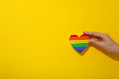 LGBT geçit töreni konsepti, sarı arka planda özgür aşk sembolü.