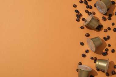 Kahverengi arka planda kahve kapsülleri ve fasulyeler, metin için boşluk