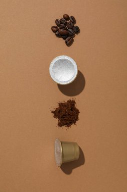 Kahverengi arka planda kahve kapsülleri ve fasulyeler, metin için boşluk