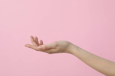 Güzel pembe bir arka planda kadın eli.