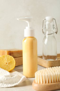 Şişeler, limon, havlu, fırça ve sabun çubukları arka planda, kapat