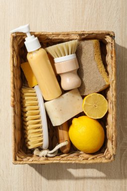 Temizlik aletleri ile sepet ve açık ahşap zemin üzerinde limon, üst görünüm
