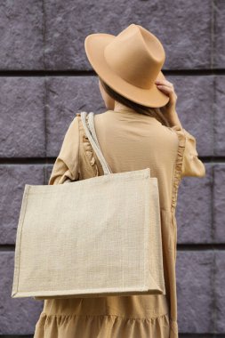 Şapkalı bir kadın ve omzunda bir çanta.