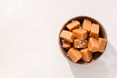 Tahta bir kasede tuzlanmış karamel küpleri