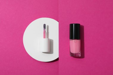 Pembe arka planda ojeli oje fırçası.