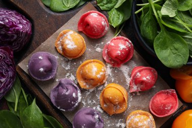 Mutfak tahtasındaki renkli hamur köfteleri ve pembe arka plandaki havlu, metin için yer