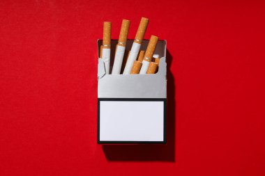Kırmızı arka planda bir paket sigara.