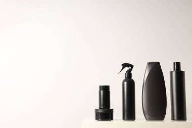 Beyaz arka planda siyah kozmetik şişeleri ve kavanoz, metin için boşluk