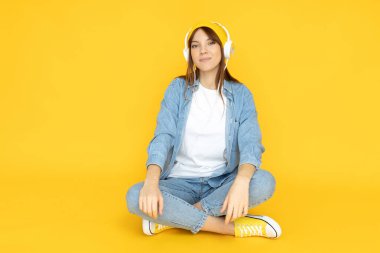 Çekici genç kız kulaklıkla müzik dinliyor.