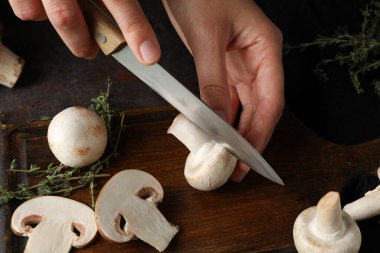 Taze kesilmiş ve tüm şampiyonlar, mutfak tahtası ve bıçak ellerinde, yakın plan.