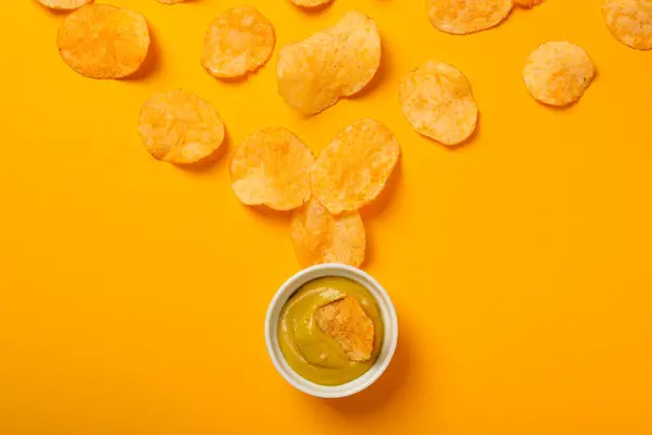 Stock image Potato chips with mustard on a yellow background