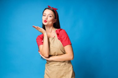 Mavi arka planda öpüşen genç kız.