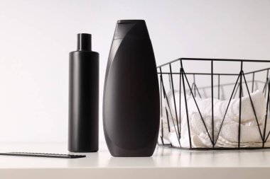 Erkek kozmetik ürünleri şişesi ve beyaz arka planda havlular.