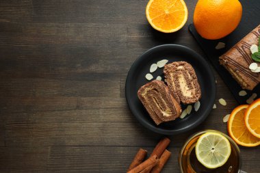 Koyu arkaplanda taze portakallı bir kasede kek yuvarla.