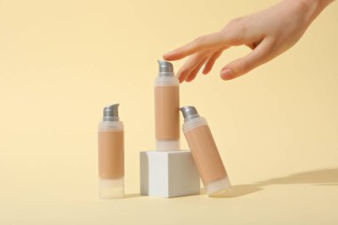 Temelli şişeler ve bej arka planda kadın eli