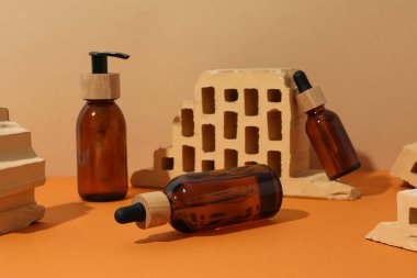 Turuncu arka planda kozmetik şişeler ve tuğlalar