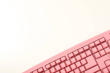 Beyaz arkaplanda pembe bilgisayar klavyesi