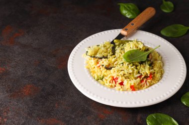 Tabakta pilav, fesleğen ve koyu gri arka planda kaşık, metin için boşluk