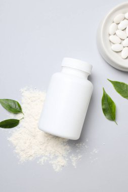 Masanın üzerinde beyaz bir şişe olan kolajen hapları.