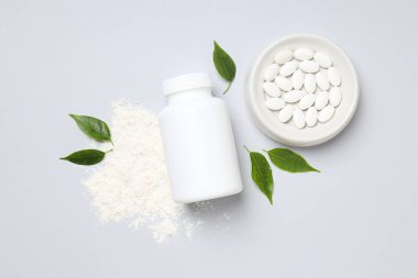 Masanın üzerinde beyaz bir şişe olan kolajen hapları.