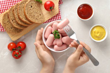 Taze domates ve ekmek dolu bir kasede küçük sosisler.