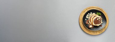 Gri arka planda bir kasede çikolata ezmeli ekmek.