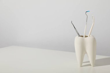 Diş aletleri ile diş şeklinde bir cam..