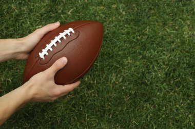 Bir adamın elinde kahverengi bir rugby topu