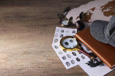 Üzerinde parmak izi, harita ve şapka olan büyüteç.