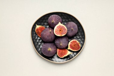 Beyaz arka planda siyah kaselerde taze incir.