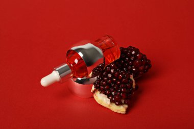 Kırmızı zemin üzerinde nar bulunan kozmetik ürünleri.